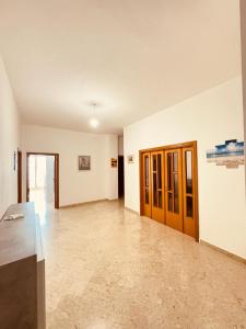 an empty room with wooden doors and tile floors at Lenny House alloggio privato in Noci