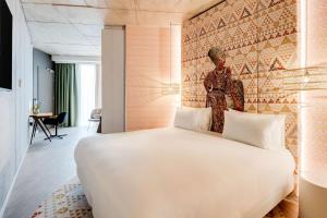 - une chambre avec un grand lit blanc dans l'établissement nhow Amsterdam Rai, à Amsterdam