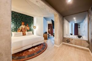 ein Schlafzimmer mit einem Bett und ein Badezimmer mit einer Badewanne in der Unterkunft nhow Amsterdam Rai in Amsterdam