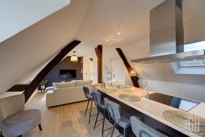 a kitchen and living room with a large island with chairs at Le Connemara / Plumereau in Tours