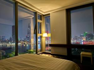 a bedroom with a large window with a view of the city at Panoramic River View, Saltwater Pool in Saigon CBD in Ho Chi Minh City