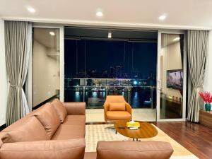 a living room with a couch and a table at Panoramic River View, Saltwater Pool in Saigon CBD in Ho Chi Minh City