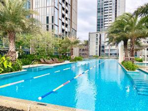 an empty swimming pool with palm trees and buildings at Panoramic River View, Saltwater Pool in Saigon CBD in Ho Chi Minh City
