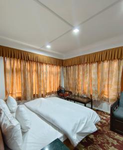 a bedroom with a large white bed and a couch at Royal galaxy in Pahalgām