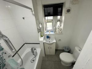 a bathroom with a toilet and a sink and a shower at Aldgate East Rooms R2 in London