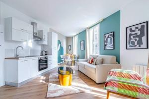 Una cocina y una sala de estar con un sofá y una mesa. en Appartement lumineux à 5 minutes de la capitale, en Bagnolet 9 fotos más