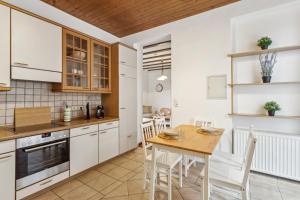 een keuken met witte kasten en een houten tafel bij Wunderschönes 4 Zimmer Altbau Apartment mit Terrasse und Patio in Wuppertal