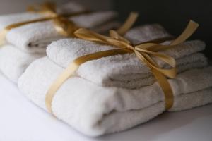 a pile of towels with a ribbon on top at Ama Casa Siracusa in Siracusa +40 photos