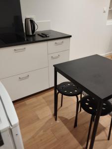 ディジョンにあるAppart hotelのキッチン(黒いテーブル、椅子2脚付)