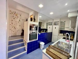 cocina con azulejos azules y pared de escalada en Casa Zen Caleta de Fuste, en Caleta de Fuste