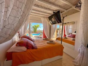 1 dormitorio con 2 camas y TV en la pared en Casa Zen Caleta de Fuste, en Caleta de Fuste