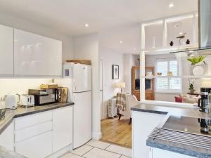 a kitchen with white cabinets and a white refrigerator at Castleton , Chichester in Chichester