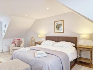 um quarto com uma cama grande e uma cadeira em Castleton , Chichester em Chichester