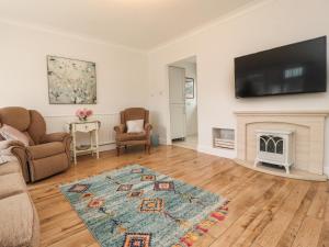 a living room with a fireplace and a flat screen tv at 14 Berwick Road in Lytham St Annes