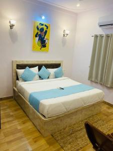 1 dormitorio con 1 cama grande con almohadas azules en The heavens villa, en Udaipur