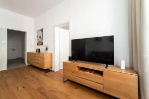 un soggiorno con una grande TV a schermo piatto di 1BR Oasis with Easy City Access by HM a Vienna