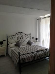 a bedroom with a bed and a window with curtains at La Casa nel Borgo in Ameglia