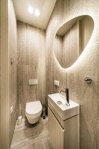 a bathroom with a toilet and a sink and a mirror at Central Park Apartments - The Luxury Collection in Kaunas
