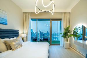 a bedroom with a white bed and a chandelier at WORLD CLASS 2BR with Downtown View in Dubai