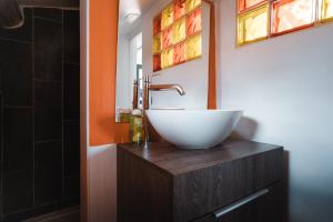 a bathroom with a white bowl sink on a wooden vanity at Terrasse tropezienne in La Ciotat +28 photos