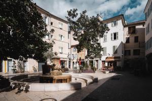 a fountain in the middle of a street with buildings at Terrasse tropezienne in La Ciotat