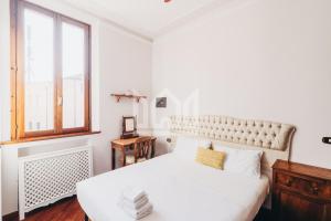 ein weißes Schlafzimmer mit einem großen Bett und einem Fenster in der Unterkunft Gold Palace ***** in Ferrara