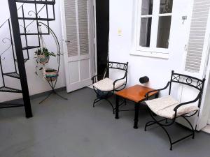 um alpendre com três cadeiras, uma mesa e uma escada em PH tipo casa con Patio - Palermo Hollywood - A cuadras de Santa Fe y Juan B Justo em Buenos Aires