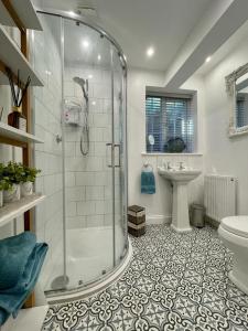 een badkamer met een douche, een toilet en een wastafel bij Mulberry Annexe in Felixstowe