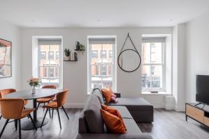 a living room with a couch and a table at Frankie Says- Cosy up in the Fitz and Flirty, a swish, modern 1 BR apartment in the heart of the West End in London