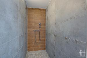 La salle de bains est pourvue d'une douche et d'un mur en pierre. dans l'établissement La Halte 2, à Veigné