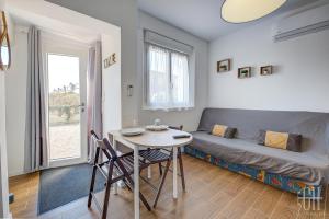 ein Wohnzimmer mit einem Tisch und einem Sofa in der Unterkunft La Halte 2 in Veigné