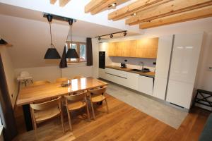 a kitchen with a wooden table and a dining room at Helly - Kvilda - apartmány in Kvilda