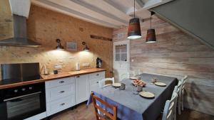 a kitchen with a table with chairs and a stove at Gite Le Cozy in Val-au-Perche
