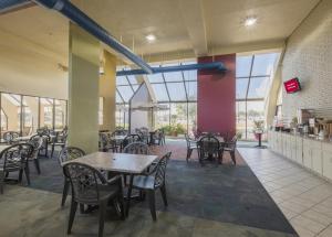 a dining room with tables and chairs and windows at Red Roof Inn & Suites Cleveland - Elyria in Elyria