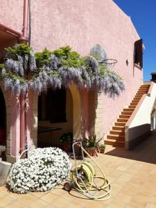 una casa con una manguera y flores en un patio en Due incantevoli stanze al mare, Sud Sardegna, en Flumini di Quartu