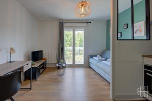 un salon avec un canapé bleu et une télévision dans l'établissement Petit Sentier / Hôpital Trousseau, à Joué-lès-Tours