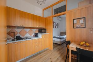 a kitchen with wooden cabinets and a table in a room at VILA KLARA apartments in Ljubljana