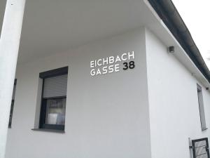 una señal en un lado de un edificio blanco en Eichbachgasse 38 en Graz