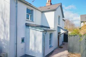 an exterior view of a white house with a fence at Quaint 3 bedroom Devon cottage in Honiton