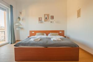 a bedroom with a large bed with two towels on it at VILA KLARA apartments in Ljubljana