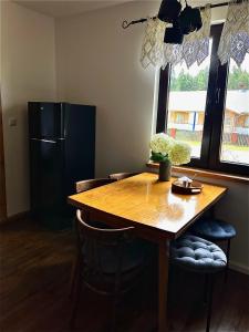 a kitchen with a wooden table and a refrigerator at Sielanka Roztocze in Pary