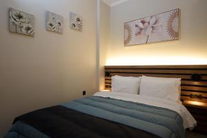 a bedroom with a bed and some pictures on the wall at 2024 superior modern studio! in Mytilene