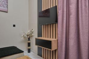 a wooden book shelf next to a pink curtain at 2024 superior modern studio! in Mytilini