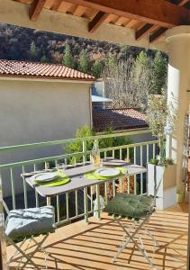 eine Terrasse mit einem Tisch und Stühlen auf dem Balkon in der Unterkunft Le Dignois in Digne-les-Bains