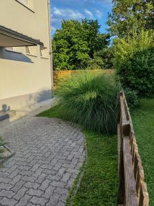 a stone walkway next to a house with tall grass at Eichbachgasse 38 in Graz