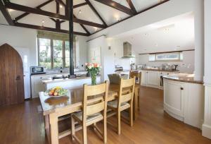 a large kitchen with a wooden table and chairs at The Old School in South Perrott