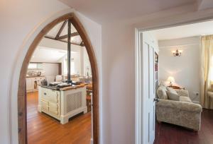 an arched doorway into a living room with a mirror at The Old School in South Perrott