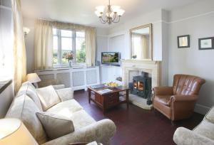 a living room with a couch and a fireplace at The Old School in South Perrott