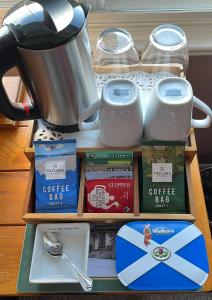 Dalgreine Guest House في بلير آتهول: رف مع بار قهوة مع وعاء الشاي وأكواب