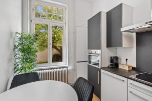 eine Küche mit einem Tisch und Stühlen sowie einem Fenster in der Unterkunft Sleek and Sophisticated in Prime Location ID18 in Luxemburg (Stadt)